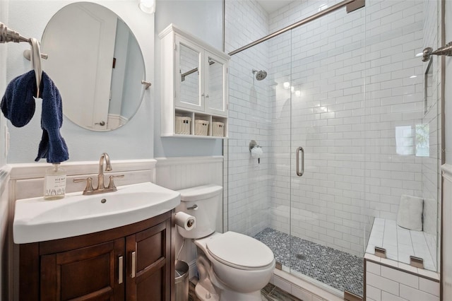 7115 Bay St, St Pete Beach, FL 33706 - full bath with a stall shower, vanity, toilet, and a wainscoted wall