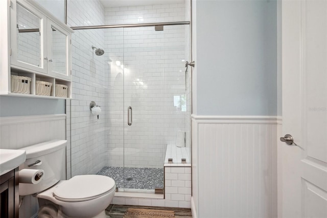 7115 Bay St, St Pete Beach, FL 33706 - bathroom featuring toilet, a wainscoted wall, a stall shower, and vanity