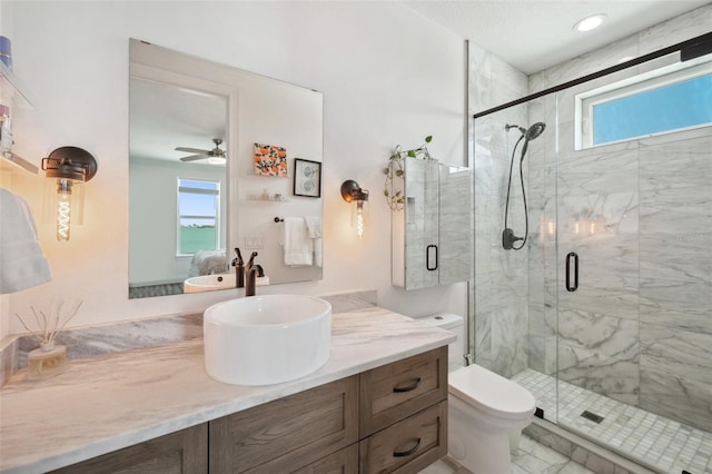 7115 Bay St, St Pete Beach, FL 33706 - ensuite bathroom featuring a marble finish shower, vanity, ceiling fan, and toilet