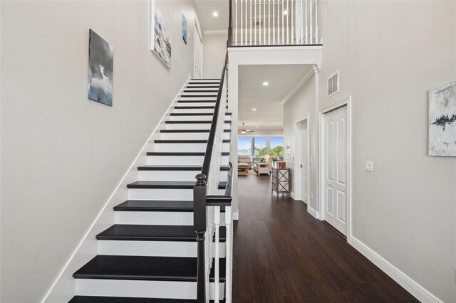 7115 Bay St, St Pete Beach, FL 33706 - staircase featuring ornamental molding, wood finished floors, baseboards, recessed lighting, and a towering ceiling