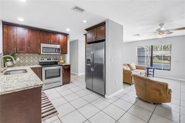 2270 Amherst Ave, Spring Hill, FL 34609 - kitchen featuring appliances with stainless steel finishes, a sink, light tile patterned floors, baseboards, and backsplash
