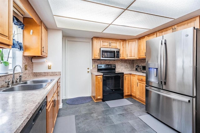 kitchen with appliances with stainless steel finishes, a sink, tasteful backsplash, and light countertops