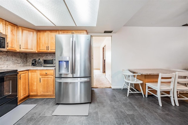 kitchen with stainless steel appliances, light countertops, a breakfast bar, and tasteful backsplash