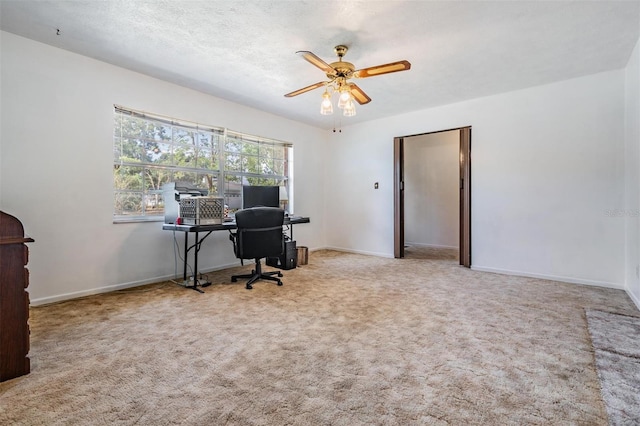 carpeted home office with a ceiling fan and baseboards