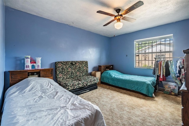 bedroom with carpet floors, ceiling fan, and a textured ceiling
