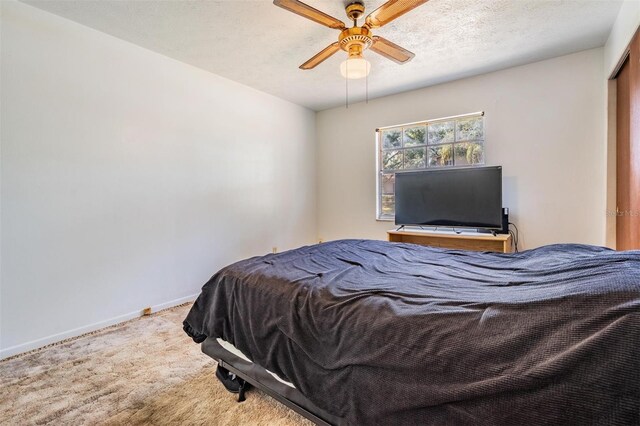 carpeted bedroom featuring baseboards and a ceiling fan