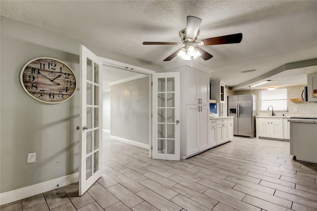 9120 Lunar Ln, Port Richey, FL 34668 - kitchen with stainless steel appliances, french doors, a ceiling fan, light countertops, and a textured ceiling