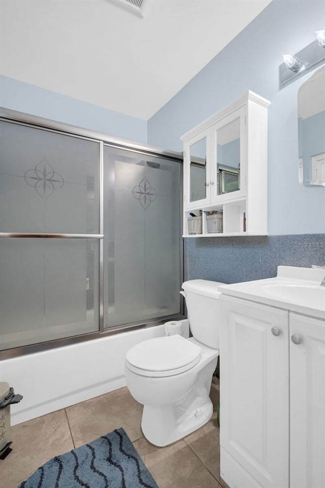 700 Bowsprit Pl, Palm Harbor, FL 34685 - full bathroom featuring vanity, shower / bath combination with glass door, toilet, and tile patterned flooring