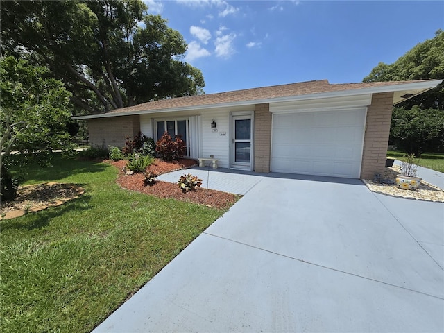 700 Bowsprit Pl, Palm Harbor, FL 34685 - ranch-style house featuring a garage, brick siding, a front lawn, and concrete driveway