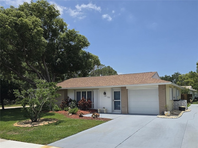 700 Bowsprit Pl, Palm Harbor, FL 34685 - ranch-style house with concrete driveway, brick siding, an attached garage, a front yard, and roof with shingles
