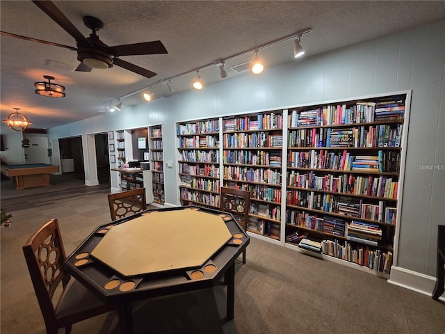 700 Bowsprit Pl, Palm Harbor, FL 34685 - living area with track lighting, bookshelves, carpet flooring, a ceiling fan, and a textured ceiling