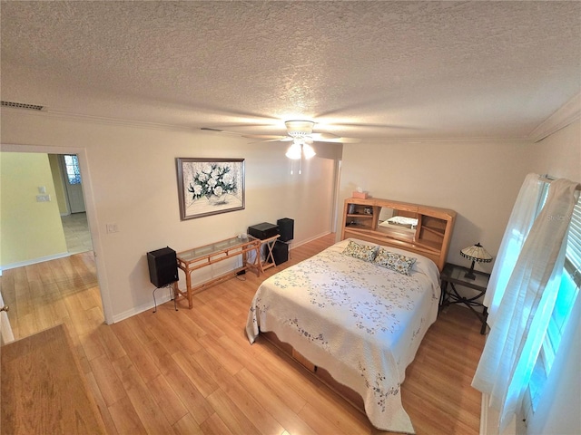 700 Bowsprit Pl, Palm Harbor, FL 34685 - bedroom with crown molding, light wood-style flooring, a textured ceiling, ceiling fan, and baseboards