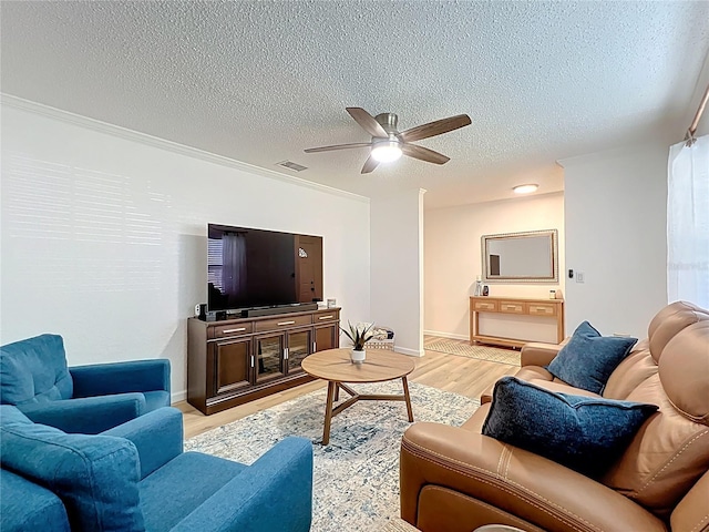 living room featuring a textured ceiling, light wood-type flooring, ceiling fan, and baseboards