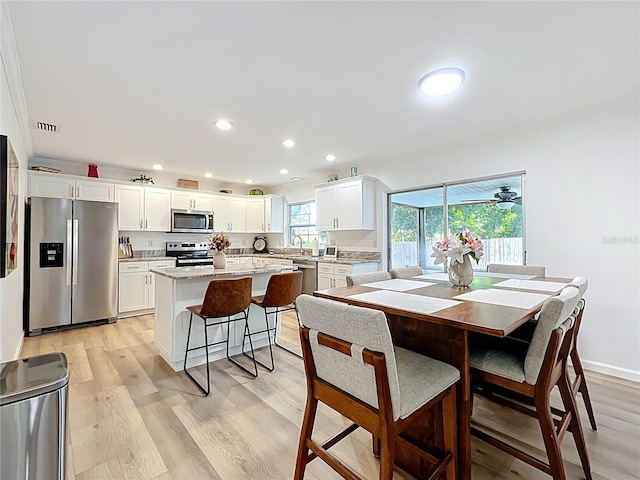 dining space with light wood-style floors and recessed lighting