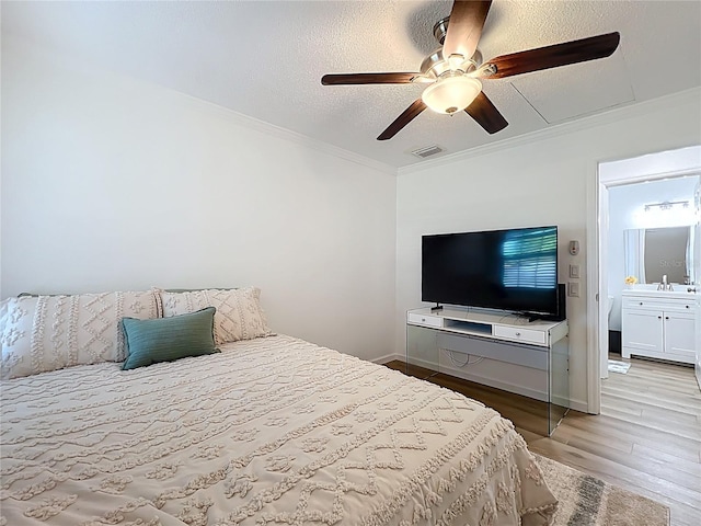 bedroom featuring wood finished floors, crown molding, a textured ceiling, a ceiling fan, and baseboards