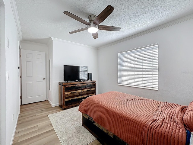 bedroom with light wood finished floors, ornamental molding, a textured ceiling, ceiling fan, and baseboards