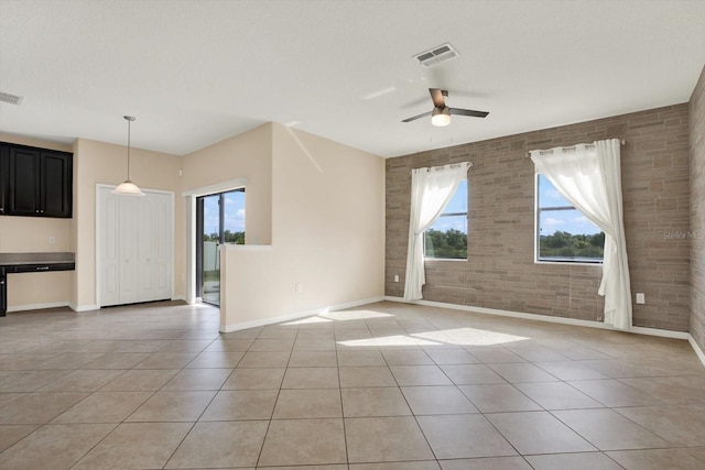 10106 Count Fleet Dr, Ruskin, FL 33575 - empty room featuring light tile patterned floors, brick wall, baseboards, healthy amount of natural light, and a ceiling fan