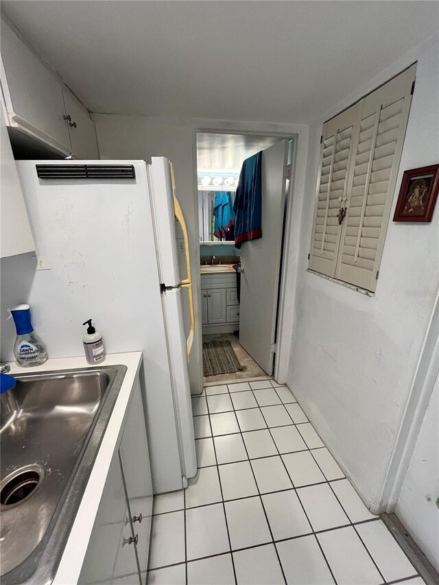 16400 Gulf Blvd Unit 307, North Redington Beach, FL 33708 - kitchen featuring a sink, light tile patterned floors, and freestanding refrigerator