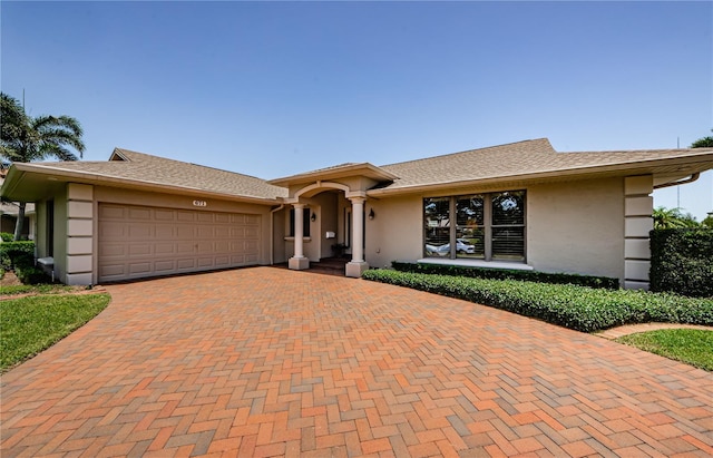 671 Tallahassee Dr NE, Saint Petersburg, FL 33702 - ranch-style home with stucco siding, decorative driveway, and a garage