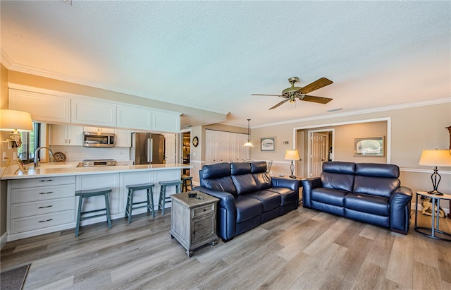 671 Tallahassee Dr NE, Saint Petersburg, FL 33702 - living area featuring light wood-style flooring, ornamental molding, a ceiling fan, and a textured ceiling