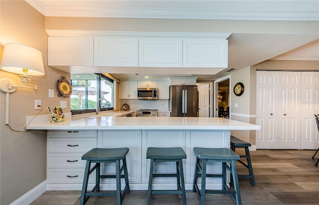 671 Tallahassee Dr NE, Saint Petersburg, FL 33702 - kitchen featuring appliances with stainless steel finishes, a sink, a breakfast bar area, a peninsula, and a textured wall