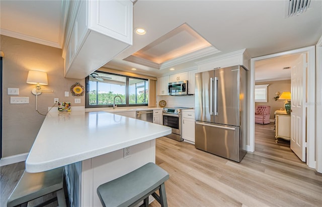 671 Tallahassee Dr NE, Saint Petersburg, FL 33702 - kitchen with stainless steel appliances, a peninsula, crown molding, a kitchen breakfast bar, and healthy amount of natural light