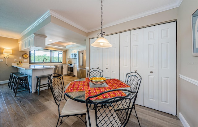 671 Tallahassee Dr NE, Saint Petersburg, FL 33702 - dining space featuring ornamental molding, light wood finished floors, and baseboards