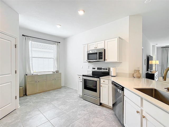 800 Reggie Rd, Winter Haven, FL 33884 - kitchen featuring stainless steel appliances, white cabinetry, a sink, and light countertops