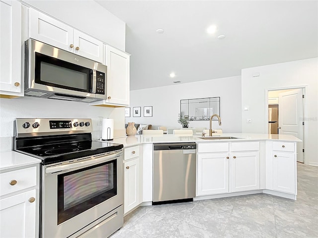800 Reggie Rd, Winter Haven, FL 33884 - kitchen with appliances with stainless steel finishes, a sink, light countertops, white cabinets, and a peninsula