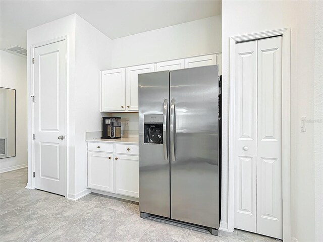 800 Reggie Rd, Winter Haven, FL 33884 - kitchen with stainless steel fridge, white cabinets, light countertops, and baseboards