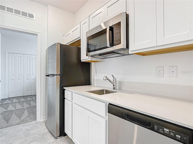 800 Reggie Rd, Winter Haven, FL 33884 - kitchen with stainless steel appliances, a sink, white cabinets, and light countertops