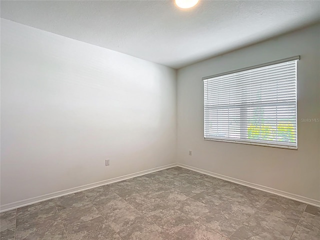 800 Reggie Rd, Winter Haven, FL 33884 - empty room with baseboards and stone finish flooring