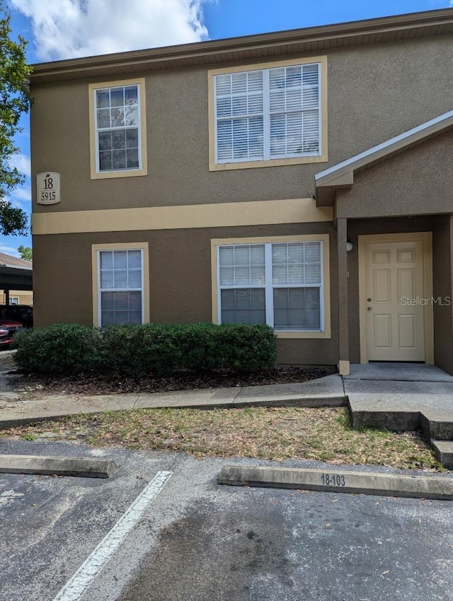 5915 Brickleberry Ln Unit 103, Zephyrhills, FL 33541 - view of front facade with stucco siding and uncovered parking