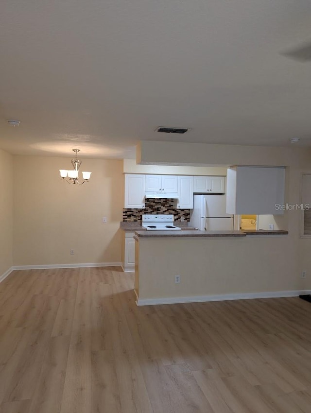 5915 Brickleberry Ln Unit 103, Zephyrhills, FL 33541 - kitchen featuring range with electric stovetop, freestanding refrigerator, light wood-type flooring, white cabinetry, and a chandelier