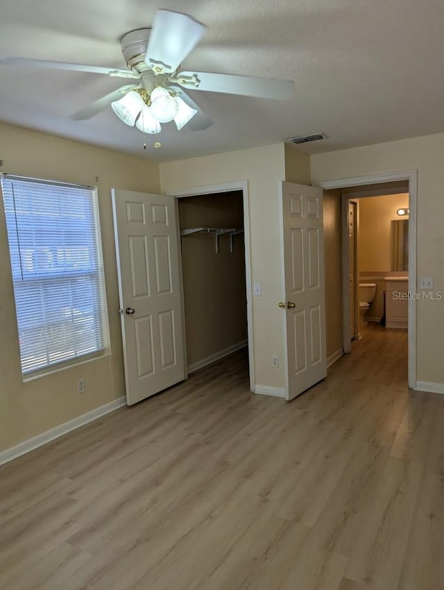 5915 Brickleberry Ln Unit 103, Zephyrhills, FL 33541 - unfurnished bedroom with light wood-style floors, baseboards, a closet, and ceiling fan