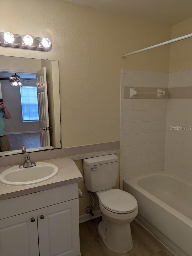 5915 Brickleberry Ln Unit 103, Zephyrhills, FL 33541 - full bathroom featuring toilet, vanity, wood finished floors, washtub / shower combination, and ceiling fan