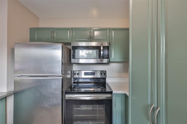 13125 Wilcox Rd Unit 16202, Largo, FL 33774 - kitchen featuring appliances with stainless steel finishes, green cabinets, and light countertops