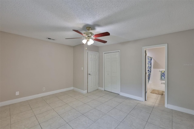 13125 Wilcox Rd Unit 16202, Largo, FL 33774 - unfurnished bedroom with light tile patterned floors, baseboards, a textured ceiling, a closet, and ceiling fan