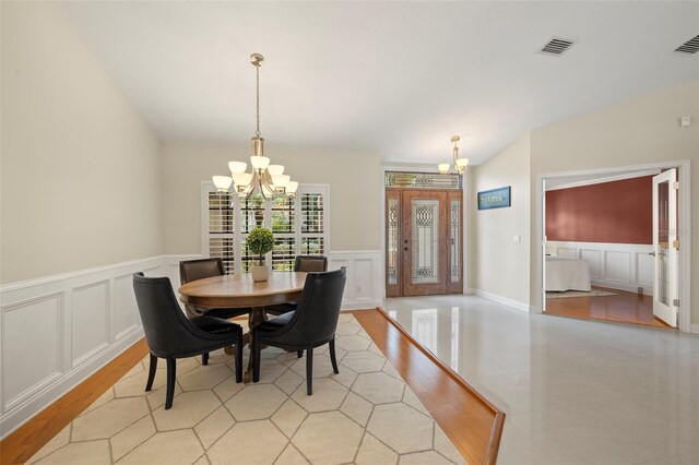 3922 Cedar Cay Cir, Valrico, FL 33596 - dining area with a chandelier, a decorative wall, light wood-style floors, and a wainscoted wall