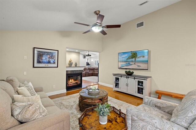3922 Cedar Cay Cir, Valrico, FL 33596 - living room with a ceiling fan, baseboards, wood finished floors, a glass covered fireplace, and high vaulted ceiling
