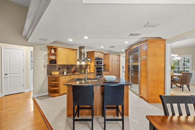 3922 Cedar Cay Cir, Valrico, FL 33596 - kitchen featuring open shelves, wall chimney range hood, appliances with stainless steel finishes, backsplash, and an island with sink
