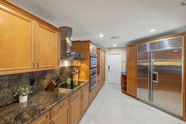 3922 Cedar Cay Cir, Valrico, FL 33596 - kitchen with appliances with stainless steel finishes, exhaust hood, brown cabinetry, backsplash, and dark stone countertops