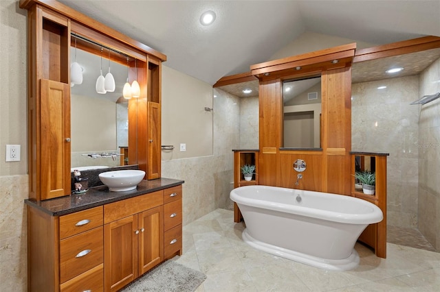 3922 Cedar Cay Cir, Valrico, FL 33596 - full bathroom featuring walk in shower, tile walls, vaulted ceiling, a soaking tub, and vanity