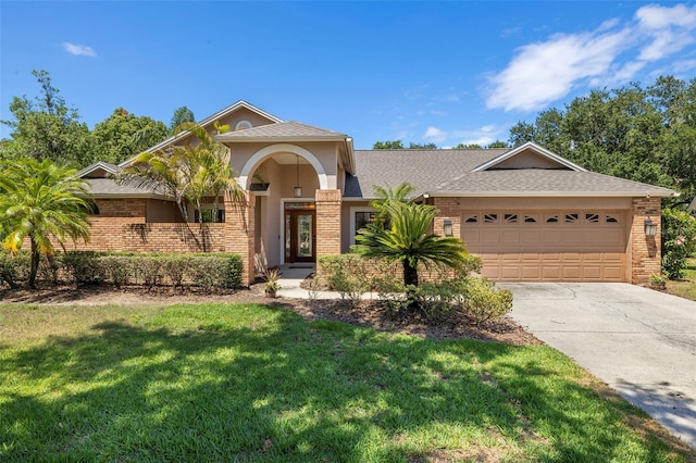 3922 Cedar Cay Cir, Valrico, FL 33596 - view of front of property with an attached garage, a front yard, brick siding, and concrete driveway