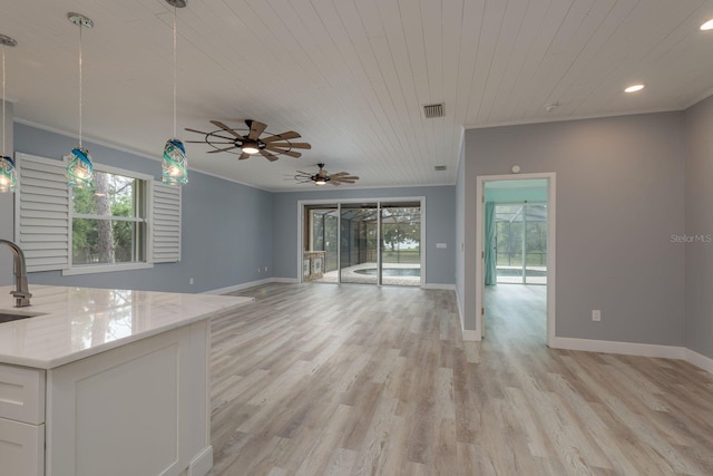 632 S Florida Ave, Tarpon Springs, FL 34689 - unfurnished living room with wood ceiling, plenty of natural light, a sink, a ceiling fan, and crown molding