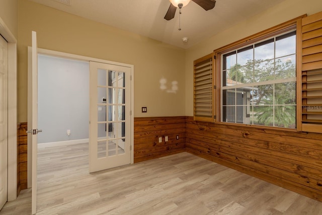 632 S Florida Ave, Tarpon Springs, FL 34689 - unfurnished room featuring light wood-style flooring, a ceiling fan, wooden walls, and a wainscoted wall