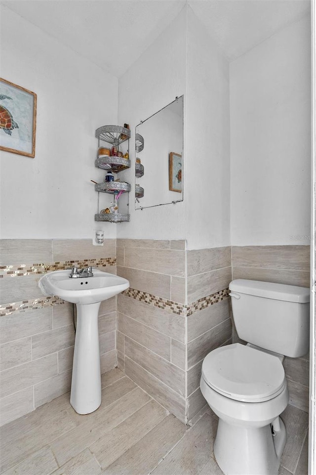 536 Ave G SE, Winter Haven, FL 33880 - half bath with tile walls, toilet, and a wainscoted wall