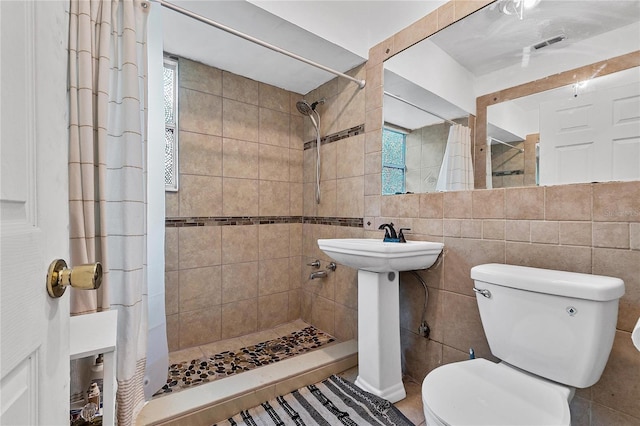 536 Ave G SE, Winter Haven, FL 33880 - full bathroom featuring a tile shower, toilet, and tile walls