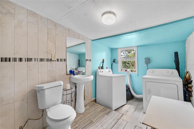 536 Ave G SE, Winter Haven, FL 33880 - bathroom featuring washer and clothes dryer, toilet, a textured ceiling, and a sink