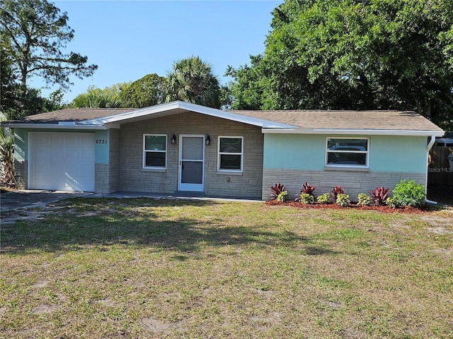 ranch-style home with an attached garage, a front lawn, and asphalt driveway